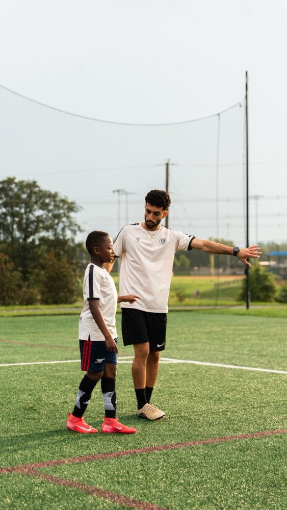 A coach demonstrating something to a player during a training session
